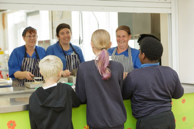 Kitchen staff serving children